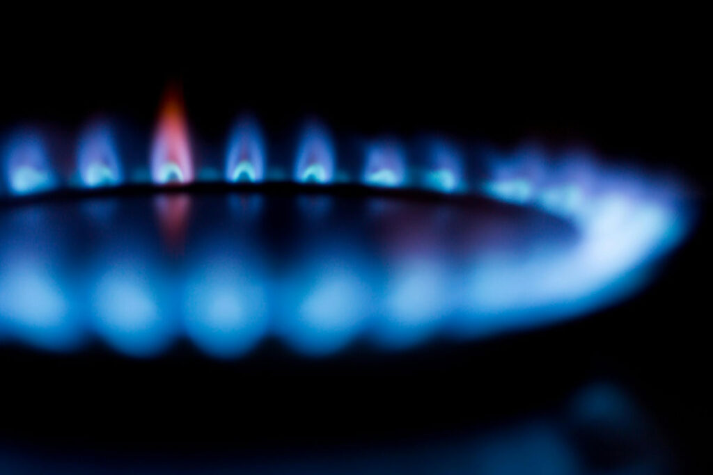 Blue flames from gas hob ring in the dark