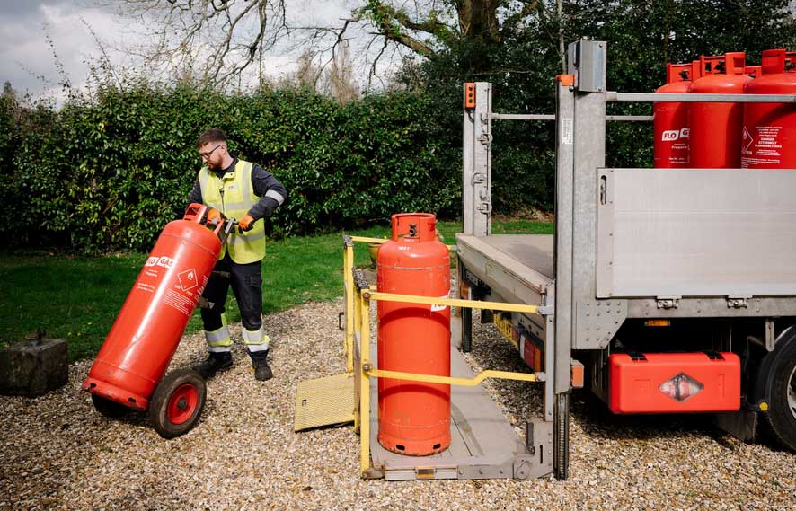 Man delivering gas cylinders outdoors.